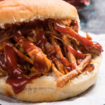 A close-up image of a pulled pork sandwich