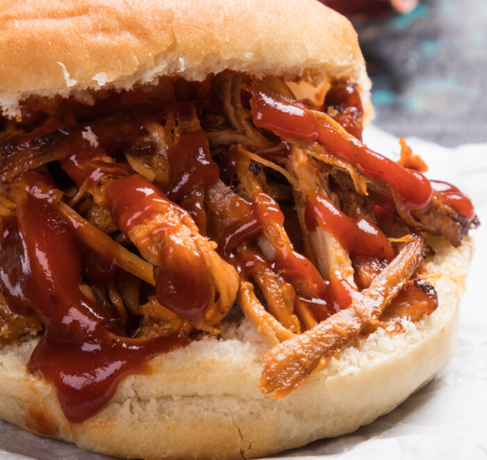 A close-up image of a pulled pork sandwich