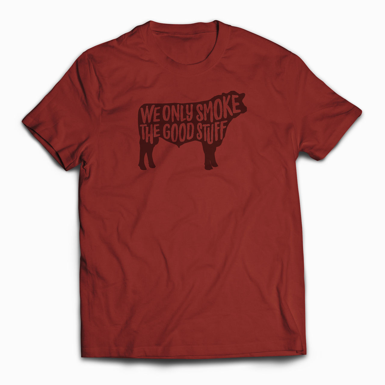 An image of a T-shirt design that says "We Only Smoke the Good Stuff" in the silhouette of a cow