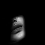 A dark moody image of a woman's face