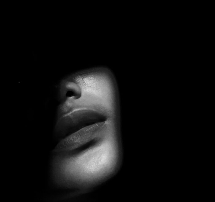 A dark moody image of a woman's face