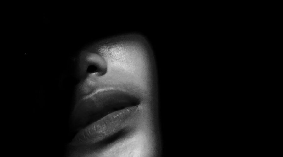 A dark moody image of a woman's face