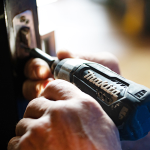 A close up image of a person using an electric screwdriver