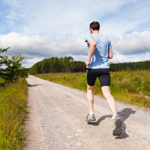 An image of a guy running on a dirt trail