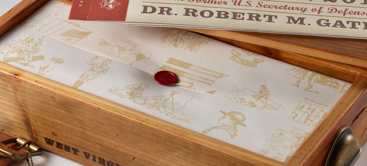An image of a wrapping paper with a wax seal inside of a wooden gift box