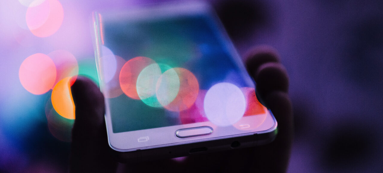 A soft focus image of a person holding a mobile phone