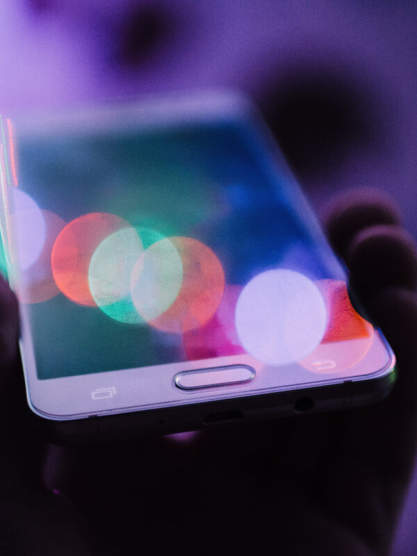A soft focus image of a person holding a mobile phone