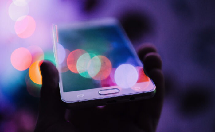 A soft focus image of a person holding a mobile phone